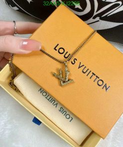 Gold chain necklace with charm on branded box.