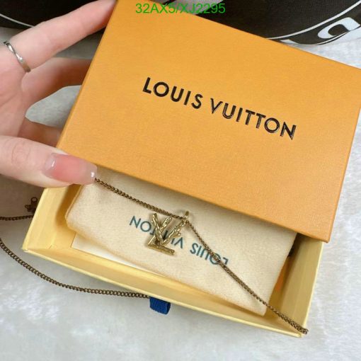 Louis Vuitton box with pendant necklace held by hand.