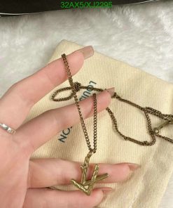 Hand holding gold cactus pendant necklace.