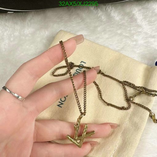 Hand holding gold cactus pendant necklace.