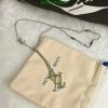 Designer logo necklace on fabric pouch.