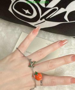 Hand displaying manicure and charm bracelet.