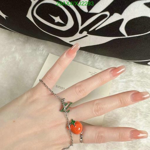 Hand displaying manicure and charm bracelet.