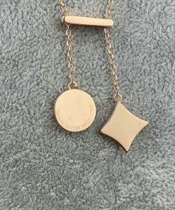 Gold pendant necklace on a gray background.