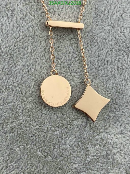 Gold pendant necklace on a gray background.