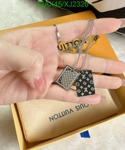 Hand holding designer pendant necklaces with box.