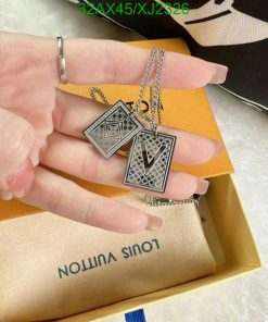 Silver geometric pendant necklaces over open jewelry box.