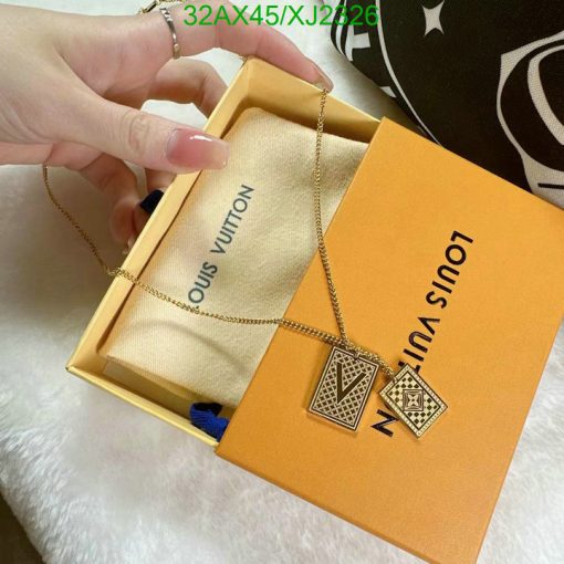 Hand holding Louis Vuitton necklace with box.