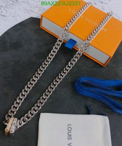 Silver chain necklace on concrete with branded box.