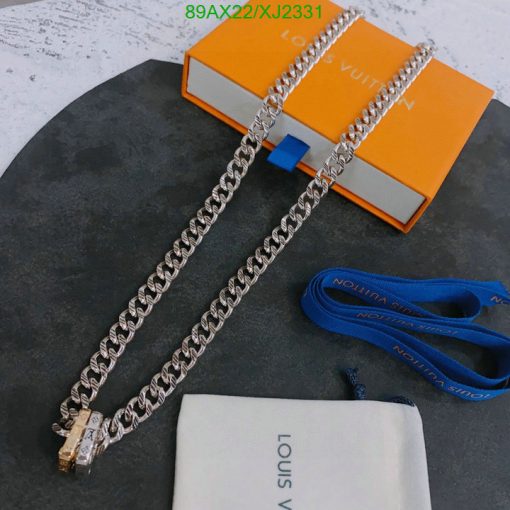 Silver chain necklace on concrete with branded box.